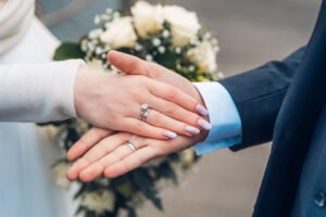 Hands of freshly married couple showing off their rings.