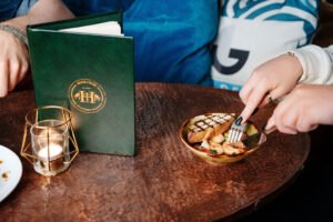 A person slicing a toastie in a bar.