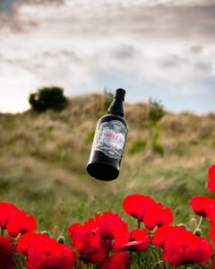 Black bottle of gin thrown in the air.